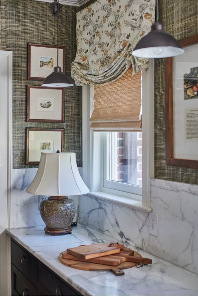 Woven bamboo blind layered under a fabric roman blind in a kitchen