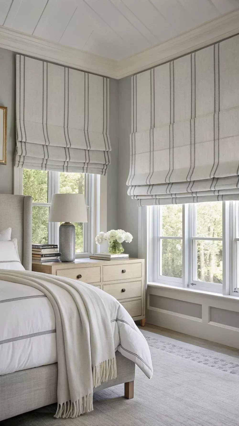 Striped roman blinds in a bedroom, raised to show the fold detail