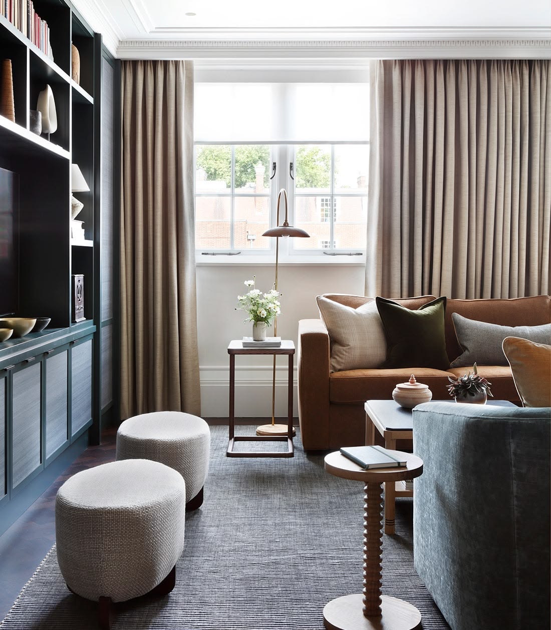 A considered sitting room with curtains hung at ceiling height