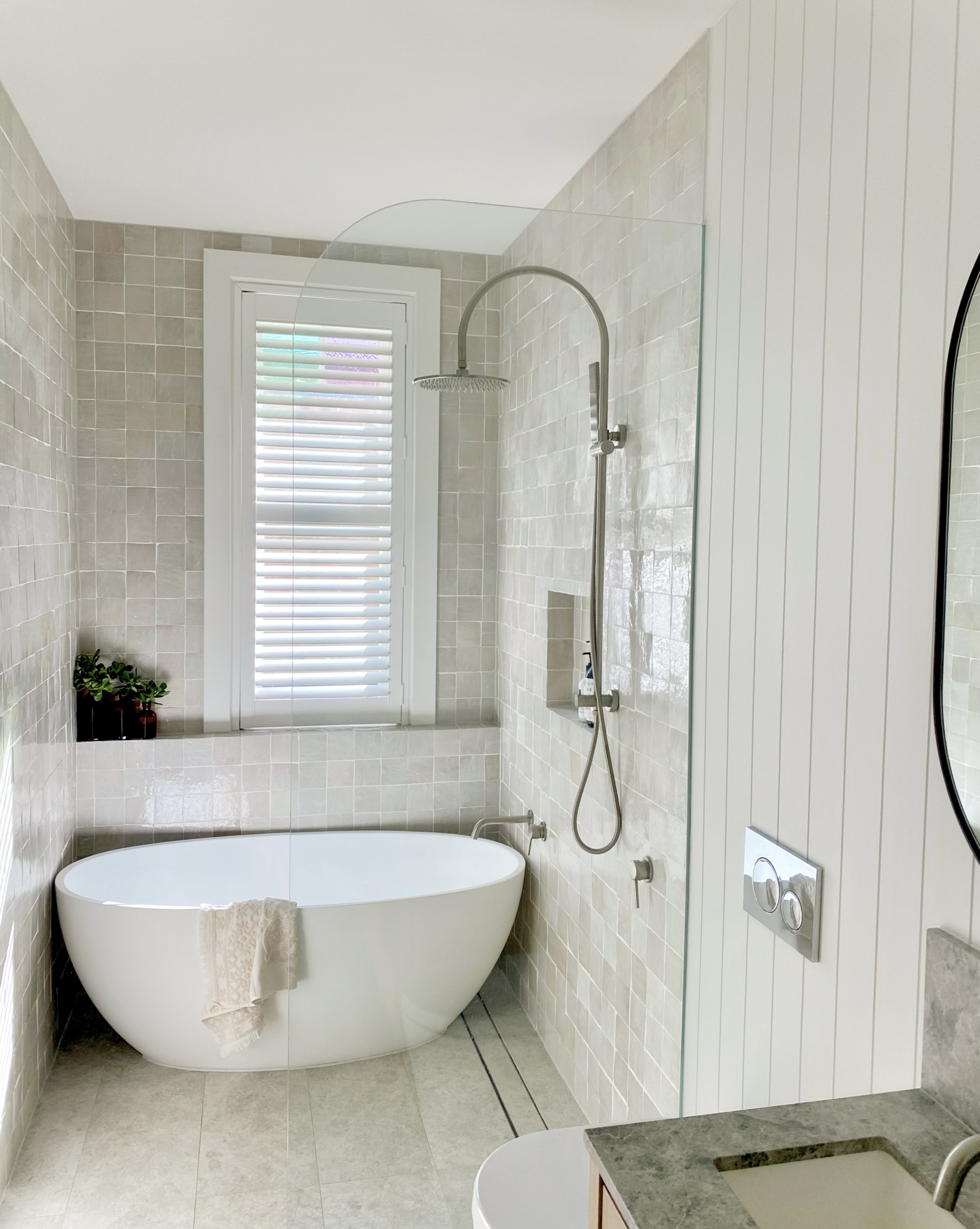 Plantation shutters in a bathroom with freestanding bath