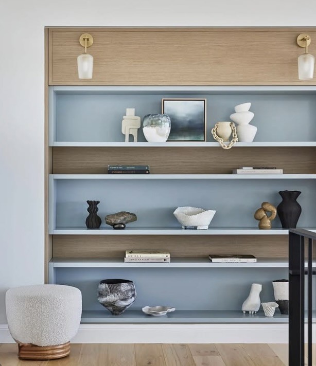 Small artworks and ceramics styled on pale blue open shelving, The Style Workshop
