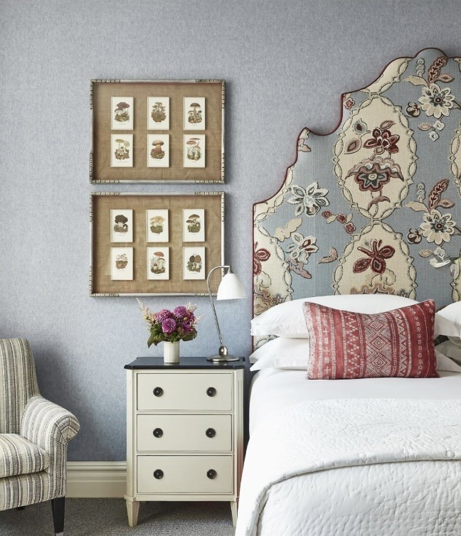 Pair of framed botanical prints above a bedside table in a soft blue bedroom, The Style Workshop