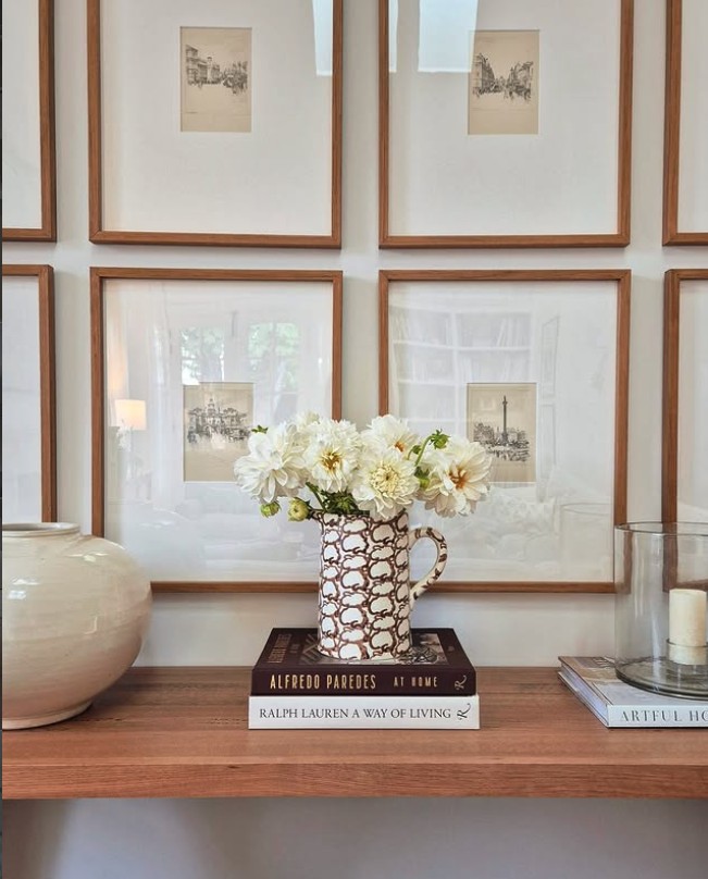 Small sketches in timber frames with generous white mats above a console, The Style Workshop
