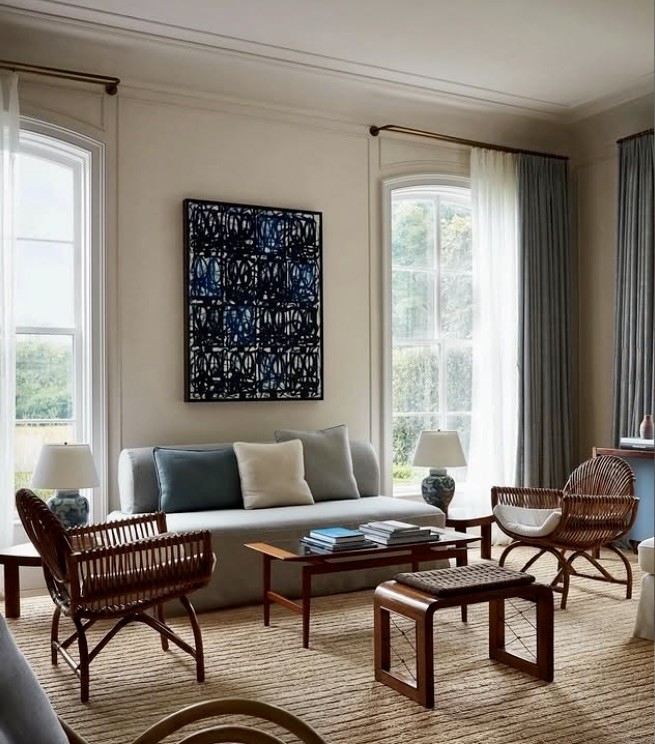 Graphic blue artwork centred between tall windows in a formal living room, The Style Workshop