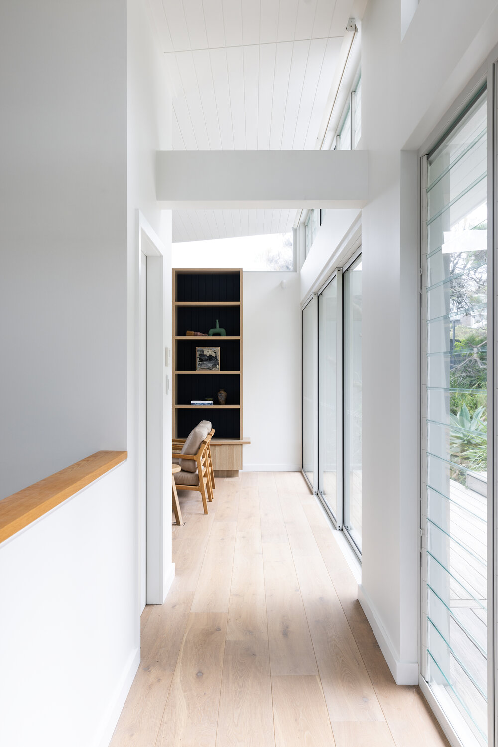 Whale Beach House hallway with glass corridor and natural timber, The Style Workshop