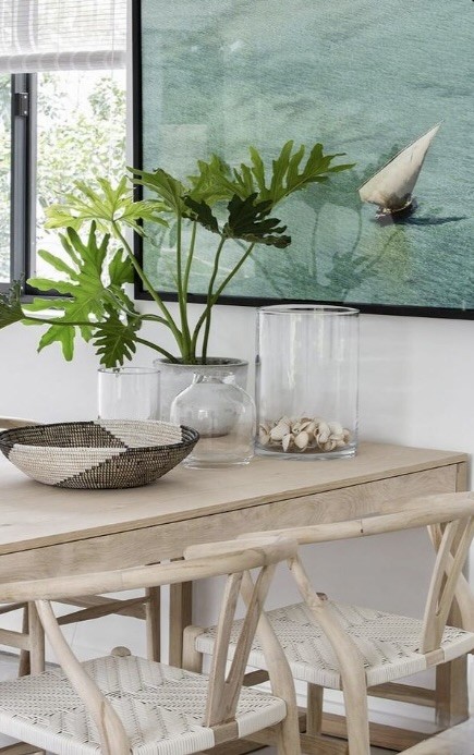 Dining table styled with a potted philodendron, glass vessels and a woven bowl, The Style Workshop