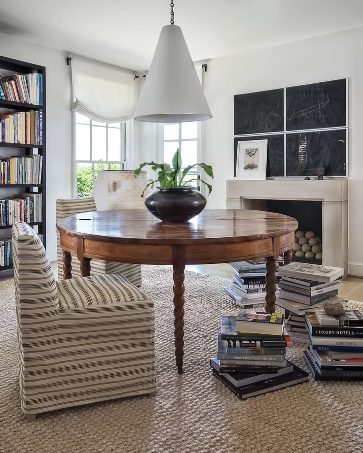 Living room with antique round table, styled bookshelves and striped armchairs, The Style Workshop