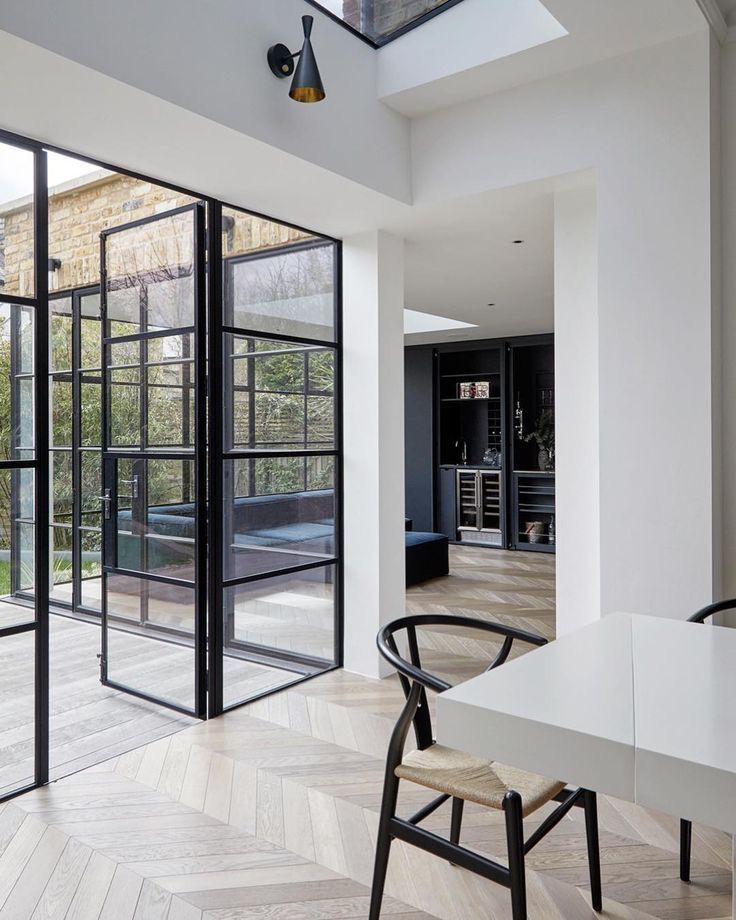 Full-height steel doors opening from a North Shore home to the garden, The Style Workshop