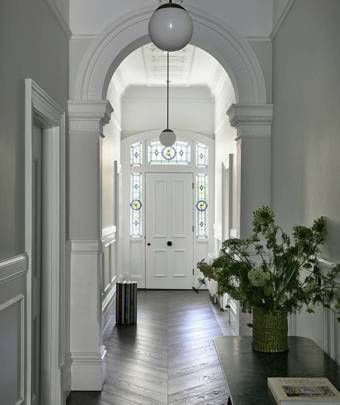 Federation entrance hallway with an arched leadlight fanlight above the front door and chevron parquet floors