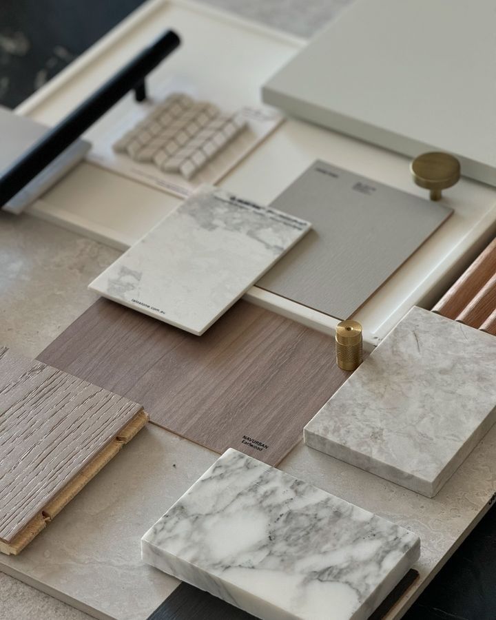 Flat lay of architectural material samples including marble, timber and stone finishes
