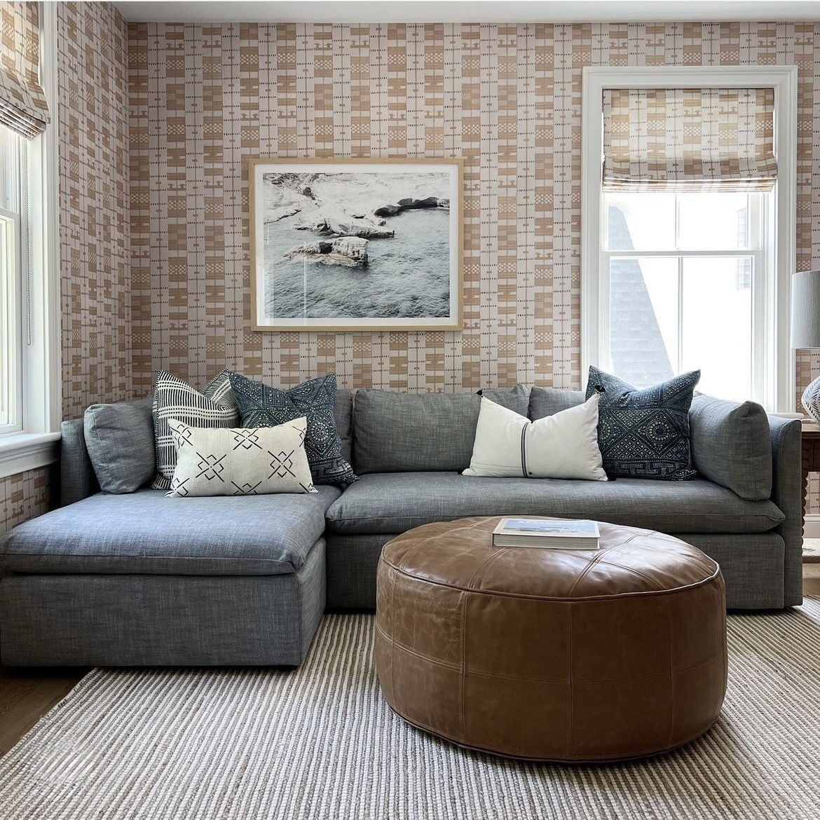 Grey sectional sofa with mixed pattern cushions and jute rug
