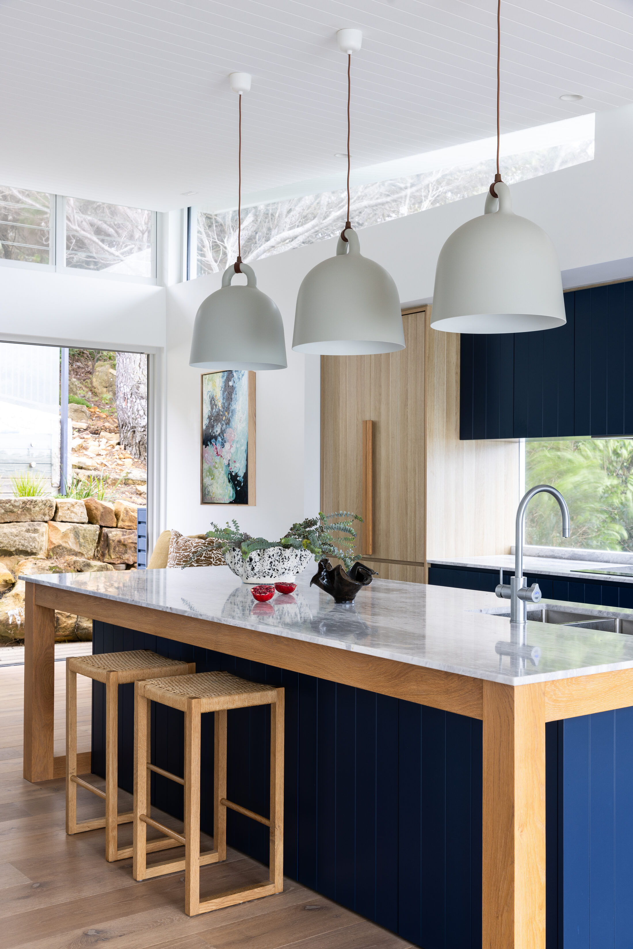 Finished kitchen with navy island joinery, oak legs and bell pendant lighting, The Style Workshop