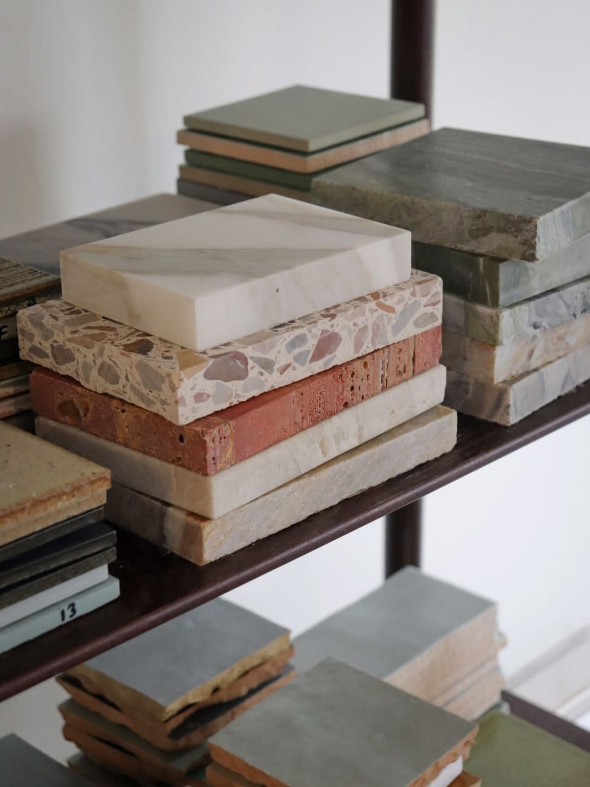 Stacked stone and tile samples on a studio shelf
