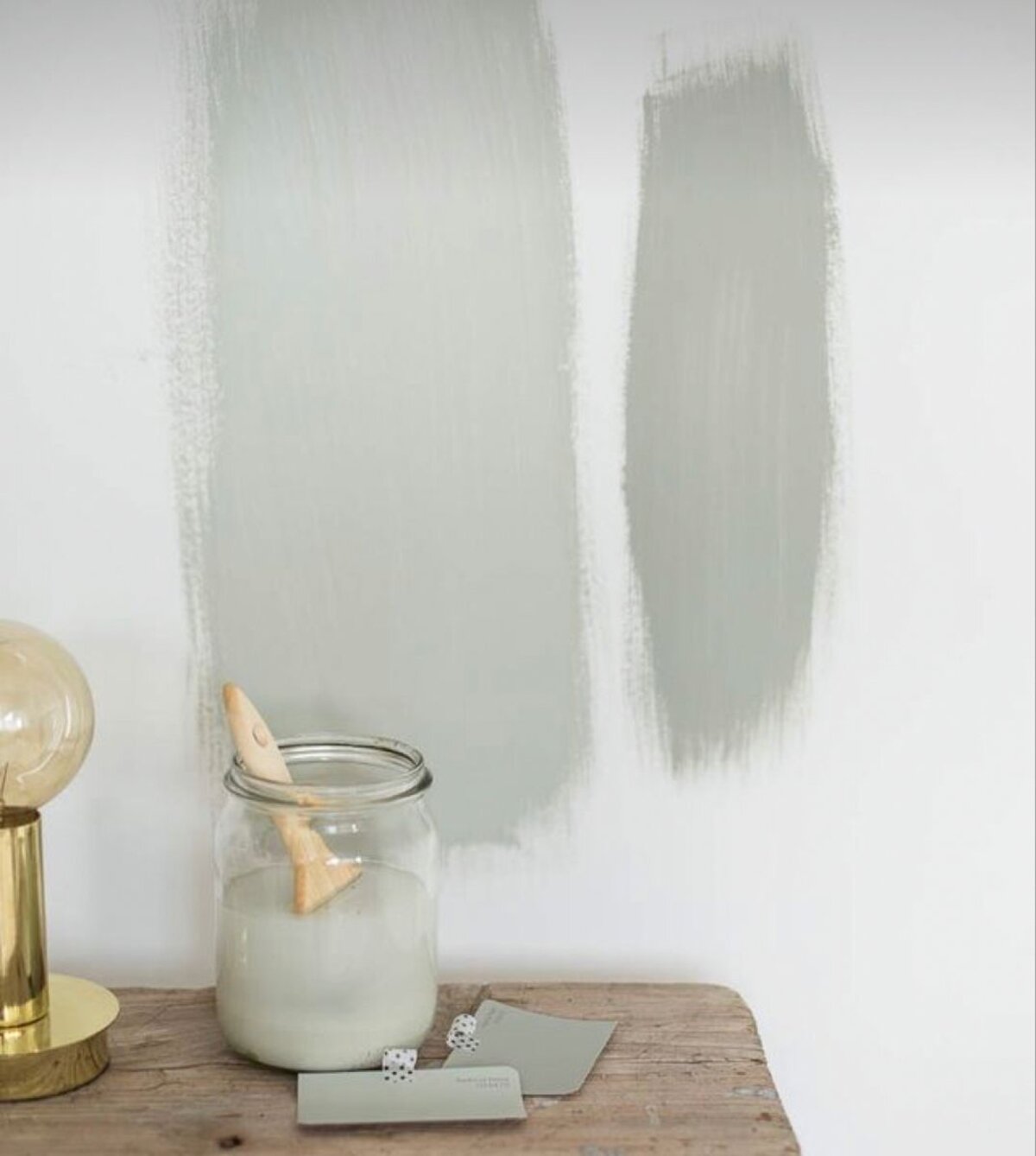 Paint swatches brushed onto a wall alongside colour chips