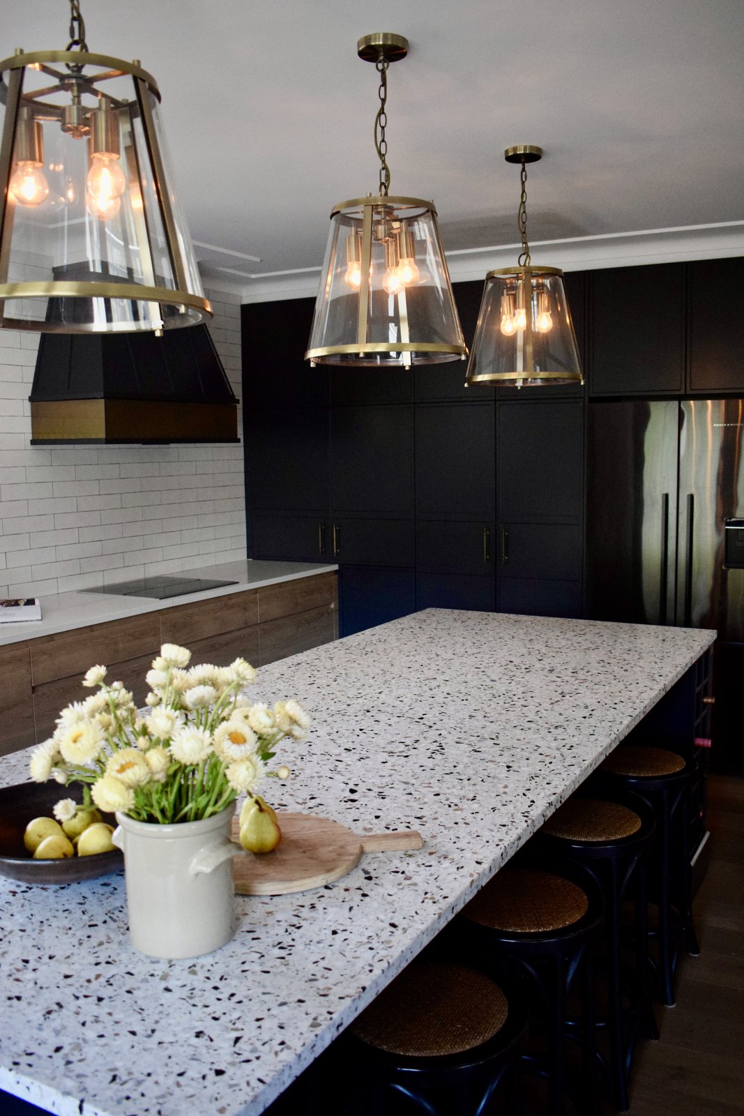 Three oversized glass and brass lantern pendants over a terrazzo kitchen island in a 1920s Mosman home, The Style Workshop