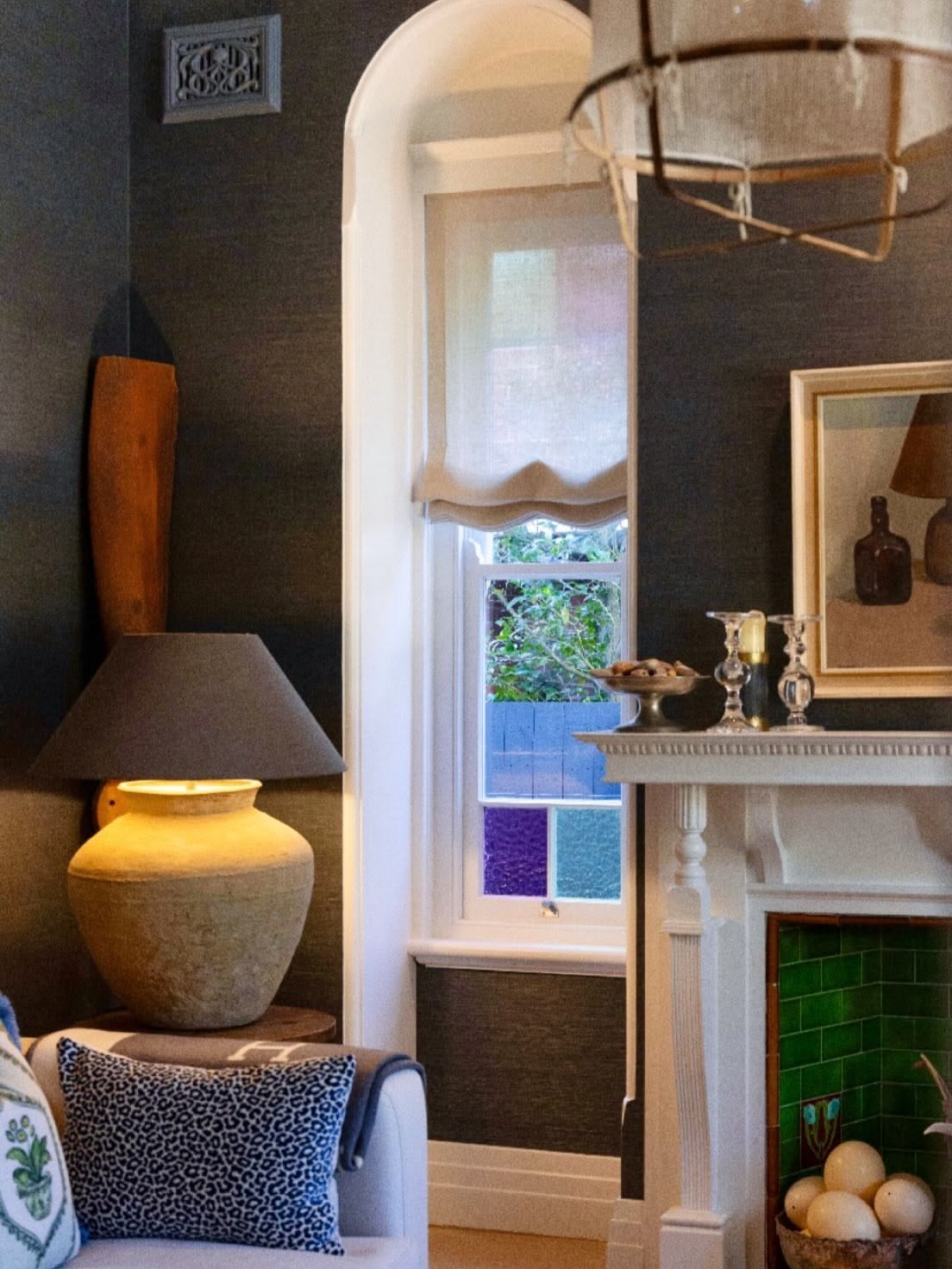 Oversized table lamp glowing beside an arched window against dark grasscloth walls in a Mosman Federation home, The Style Workshop