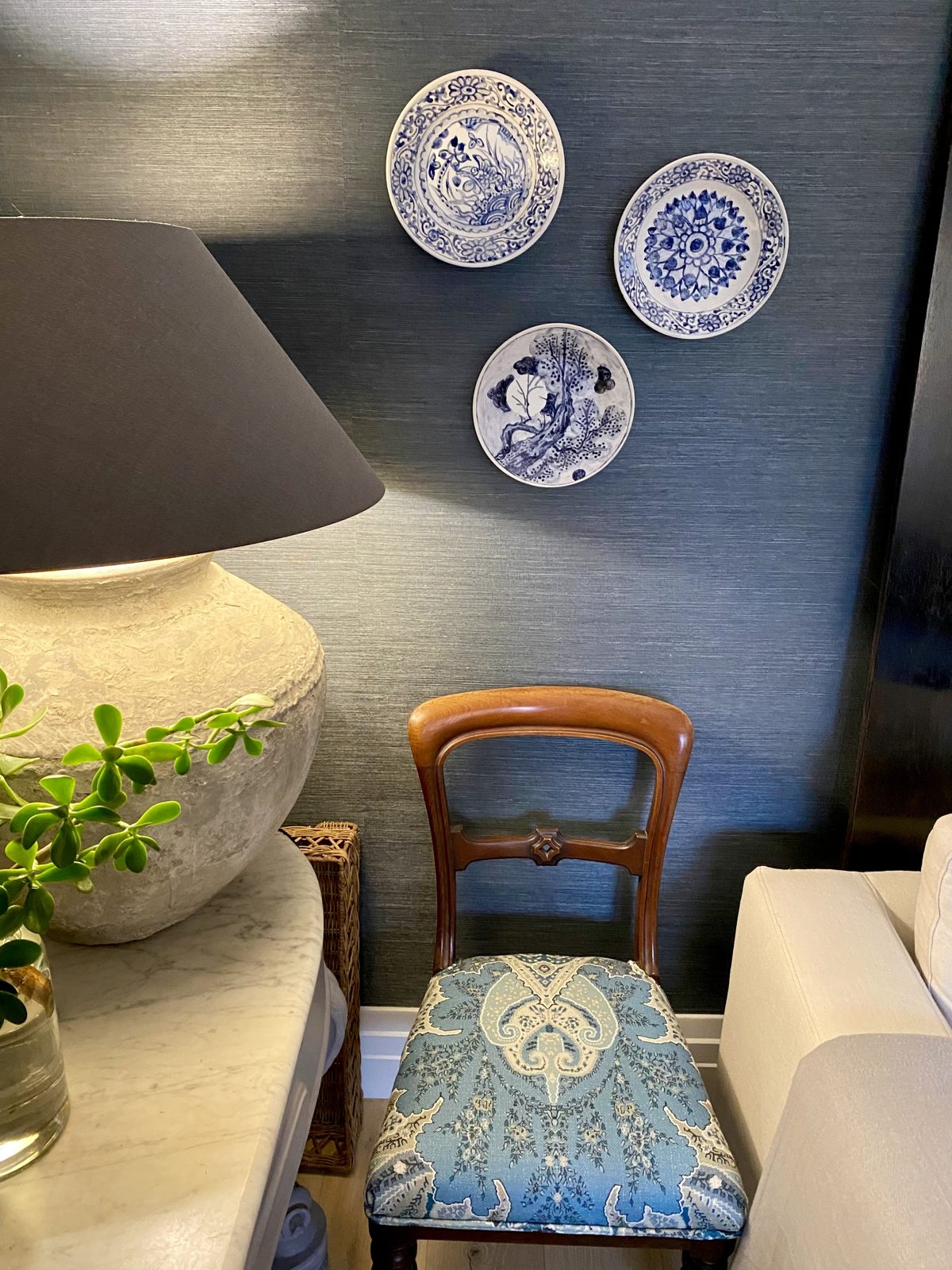 Antique timber chair with blue patterned seat beneath blue and white plates, The Style Workshop