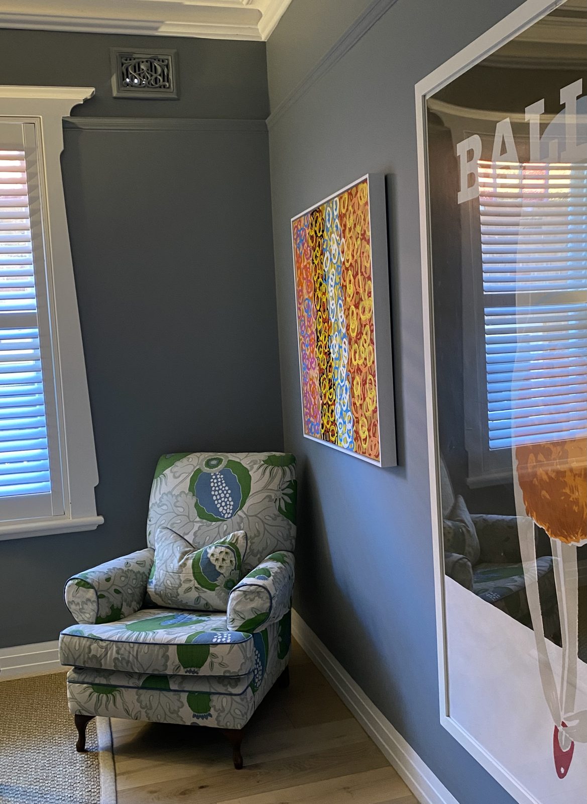 Vintage armchair in a botanical fabric beside a vibrant contemporary artwork, The Style Workshop