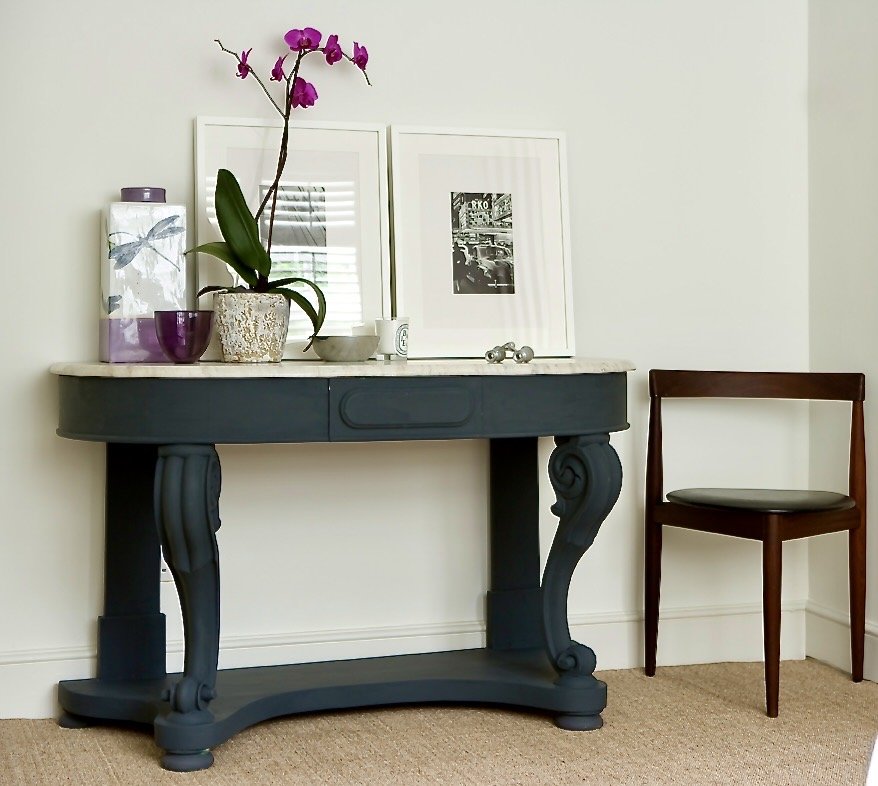 Painted vintage console with carved legs beside a mid-century style chair, The Style Workshop