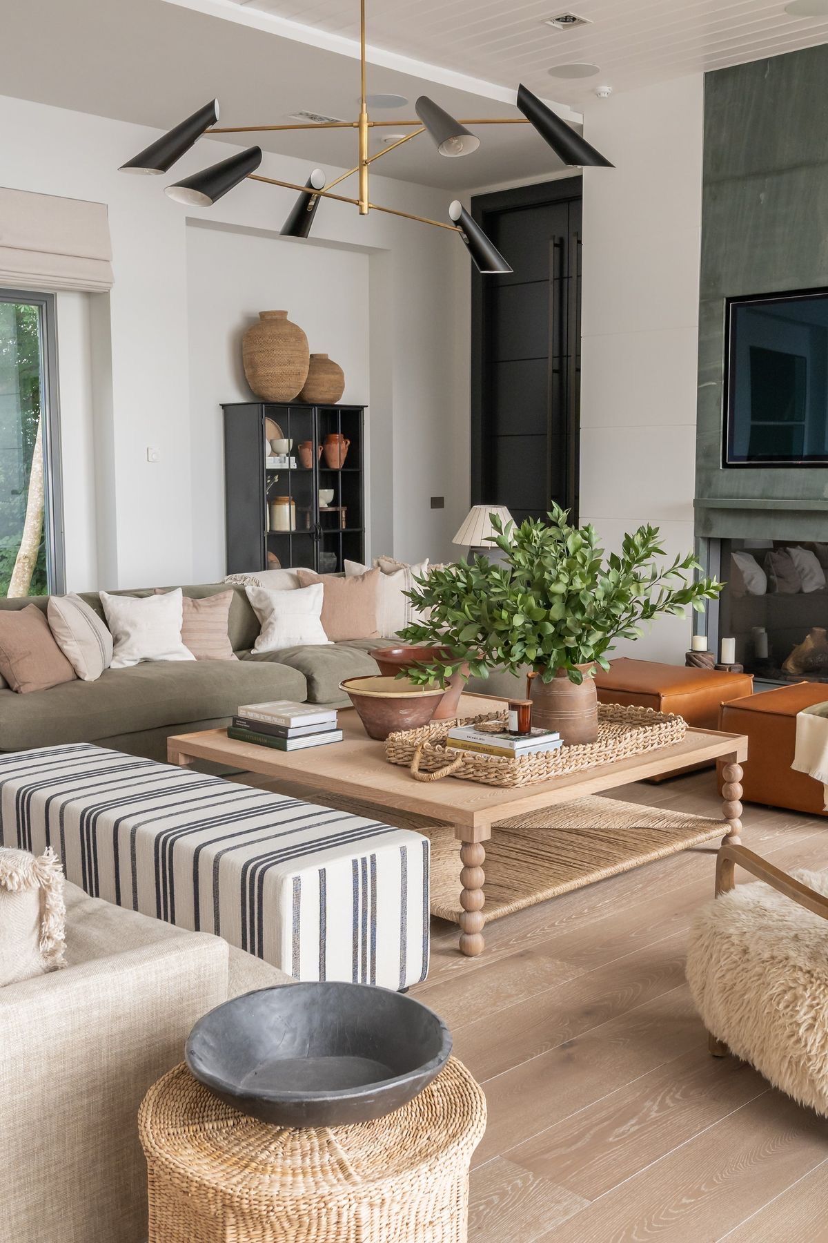 Living room with striped ottoman, woven textures and mixed pattern cushions