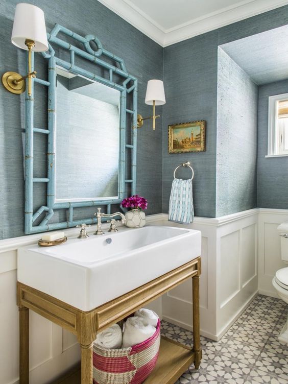 Blue grasscloth powder room with bamboo mirror and timber vanity