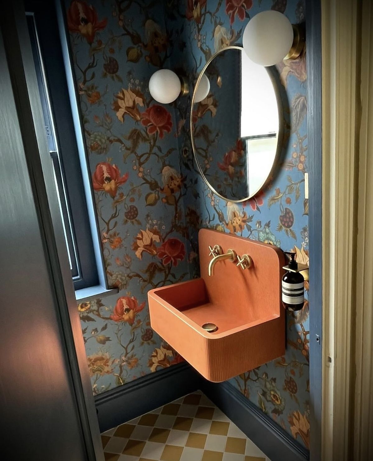 Floral wallpaper powder room with terracotta basin and checkerboard floor