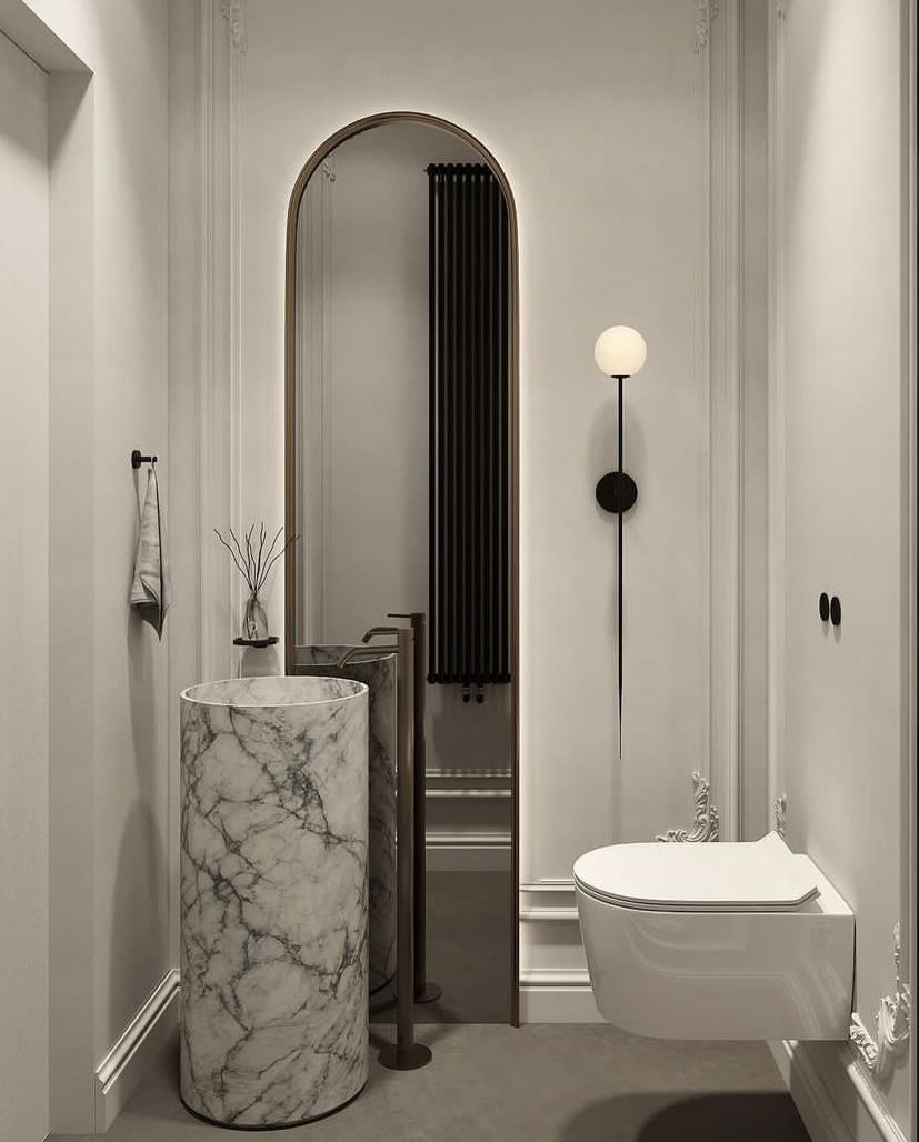 Neutral powder room with cylindrical marble pedestal basin and tall arched mirror