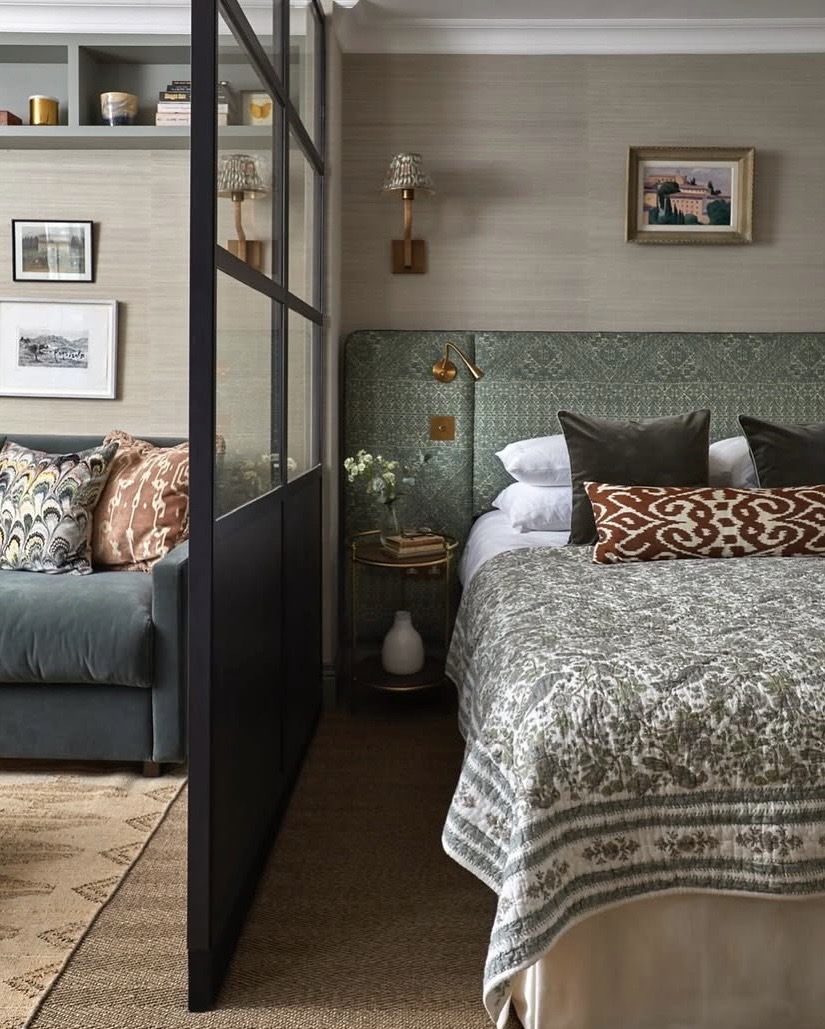Bed positioned behind a steel-framed glass partition in a studio apartment, The Style Workshop