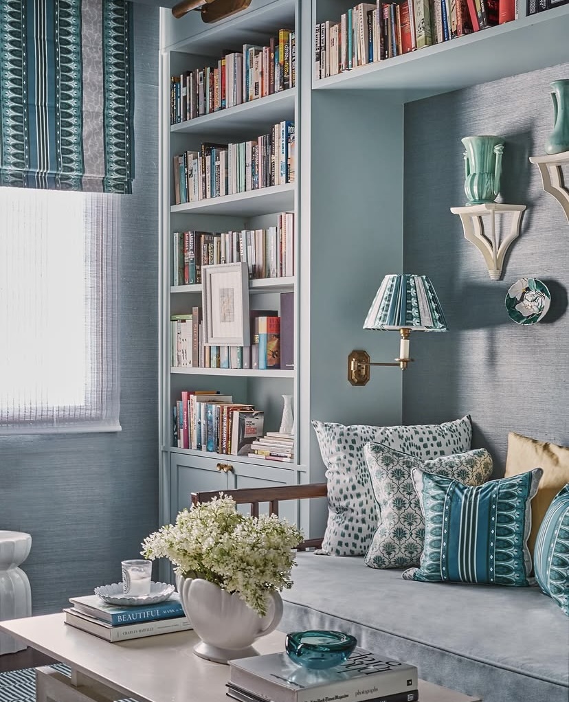 Reading nook with layered blue and teal tones, patterned cushions and a built-in bookshelf, The Style Workshop
