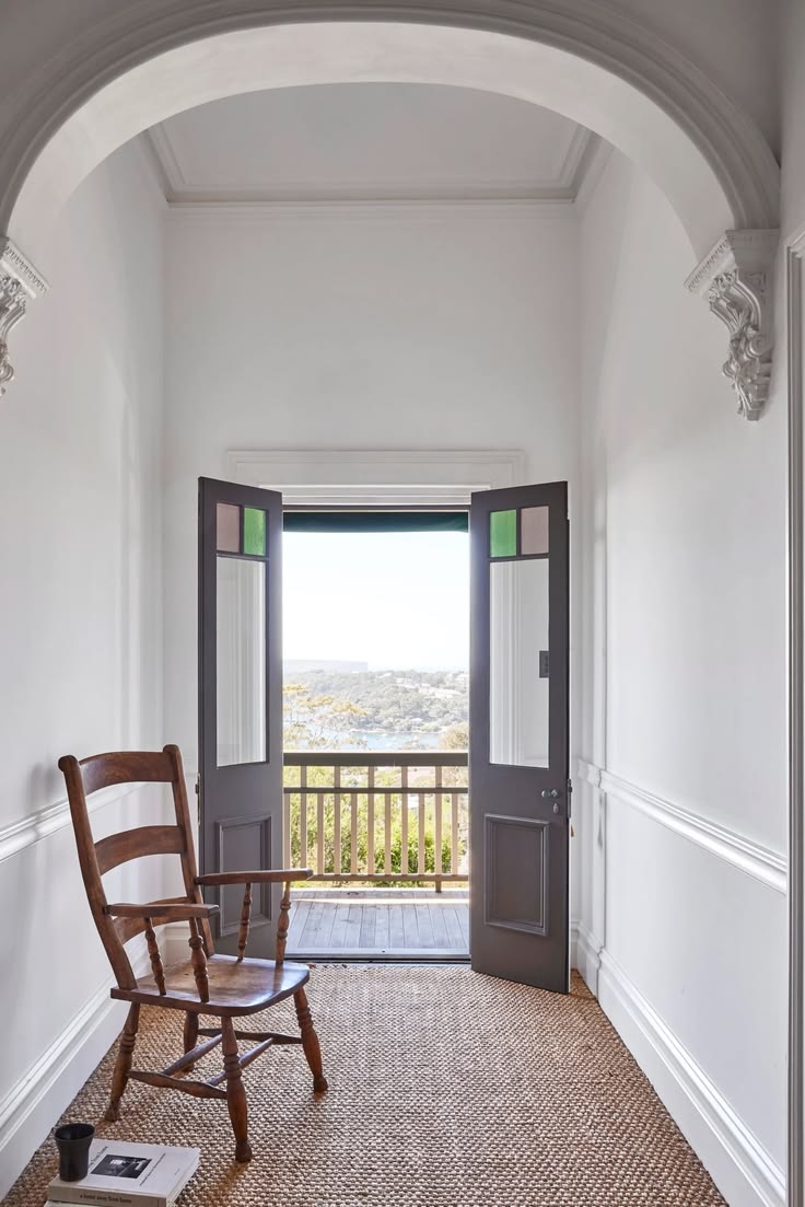 Federation interior hallway with ornate plaster arch and French doors open to a harbour view