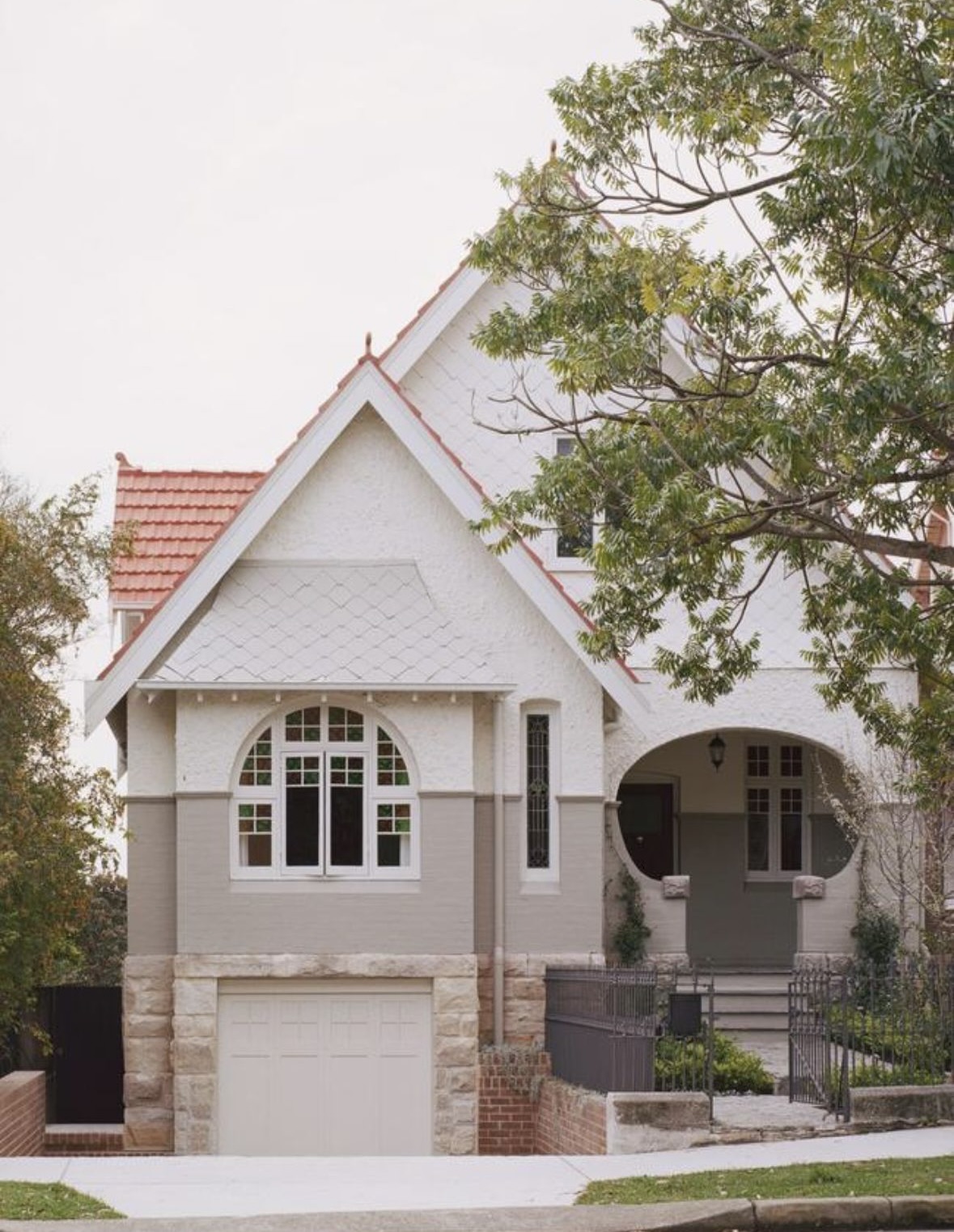 Queen Anne home exterior with rendered facade, arched windows and ornate detailing
