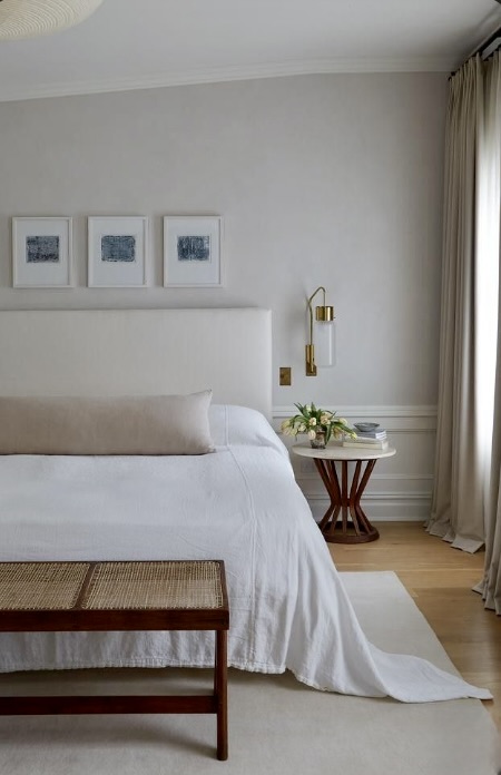Neutral bedroom with generous clearance around the bed and a cane bench at the foot, The Style Workshop