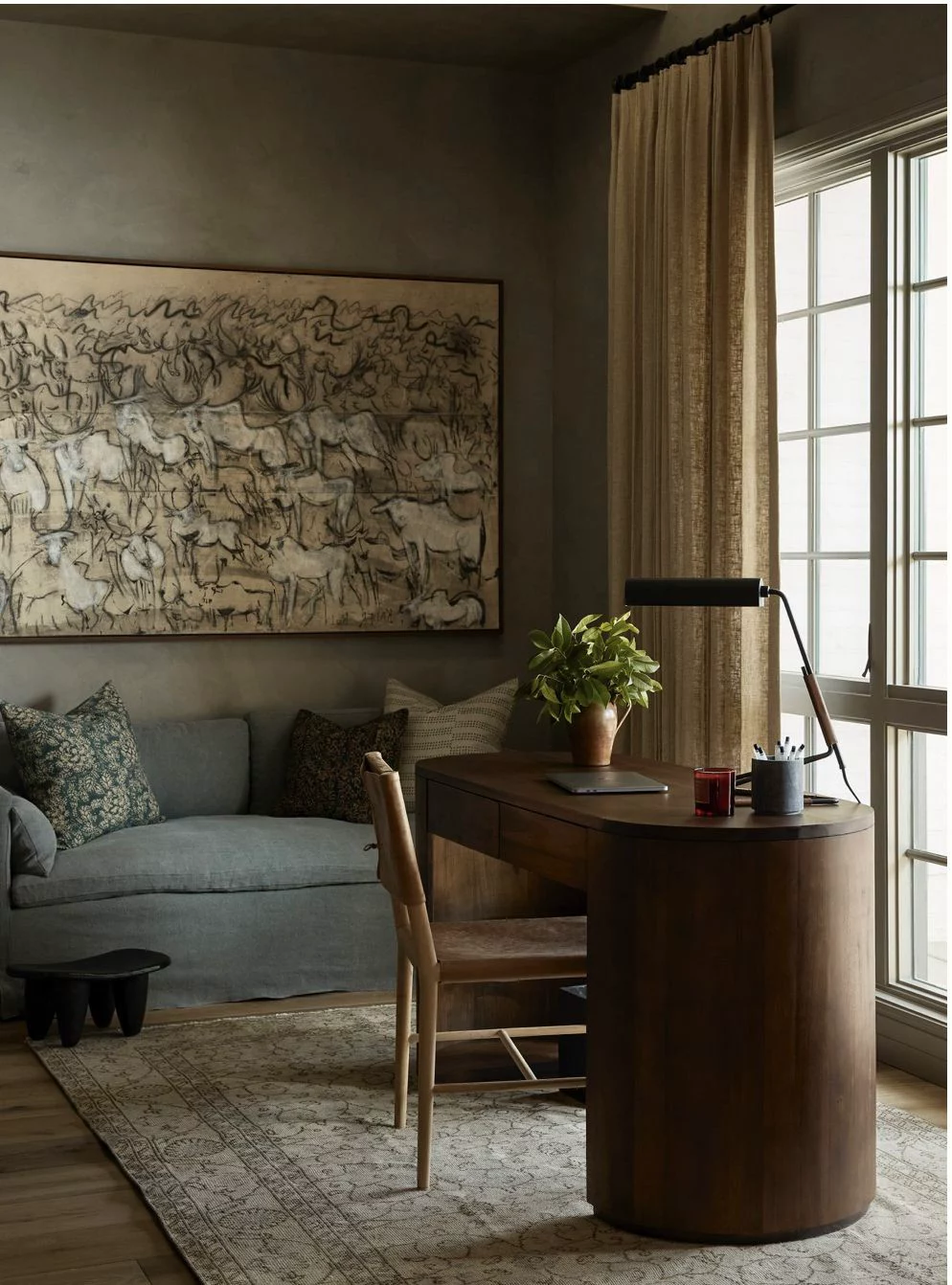 A considered sitting room in winter — linen sofa, patterned rug, linen curtains and layered textiles