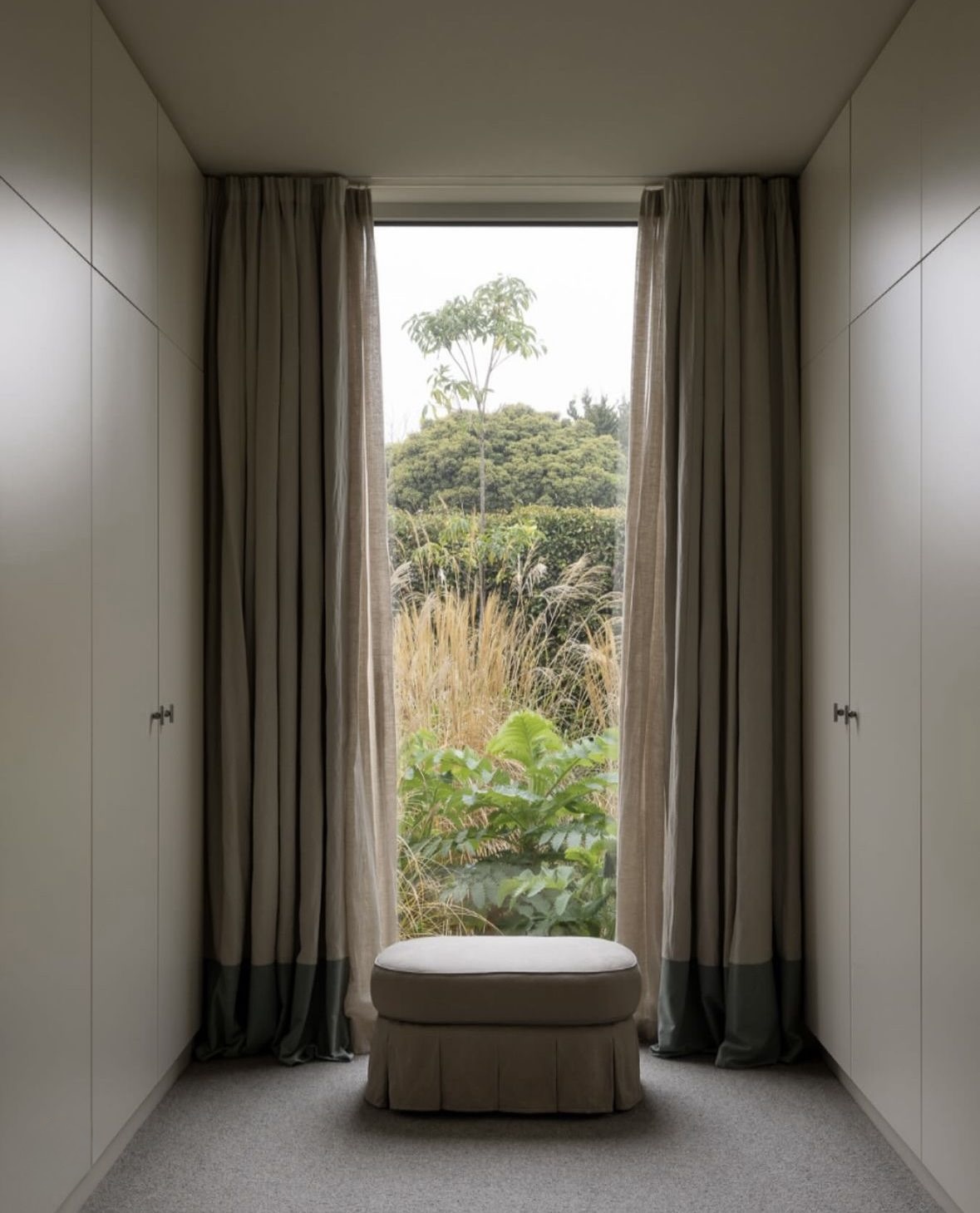 Floor-length linen curtains hung ceiling-high — a considered window treatment in a refined interior
