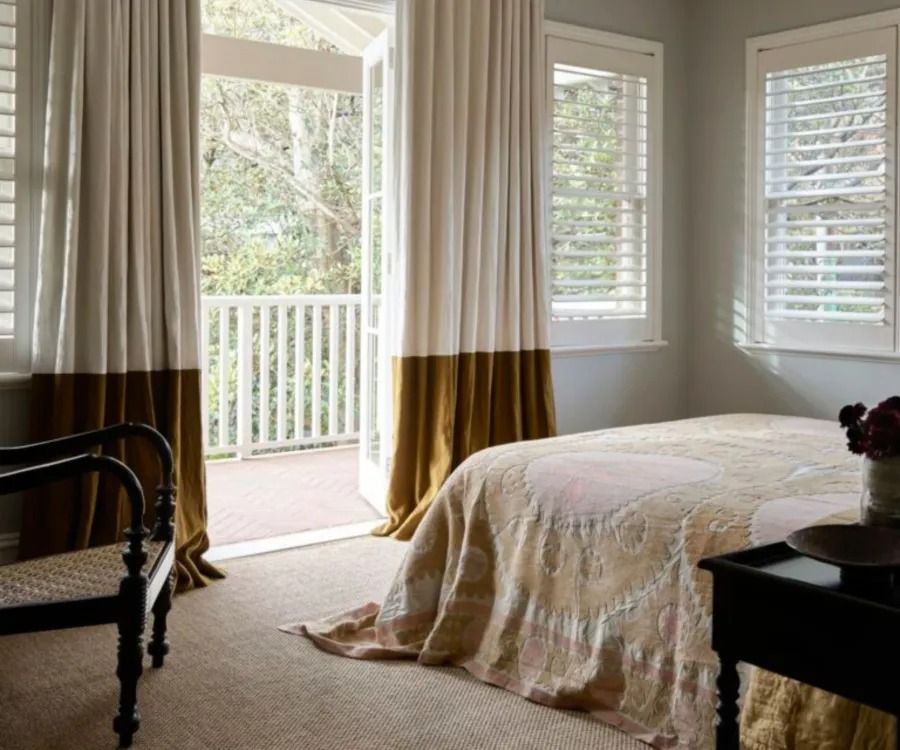 A bedroom in winter — two-tone floor-length curtains and layered bedding